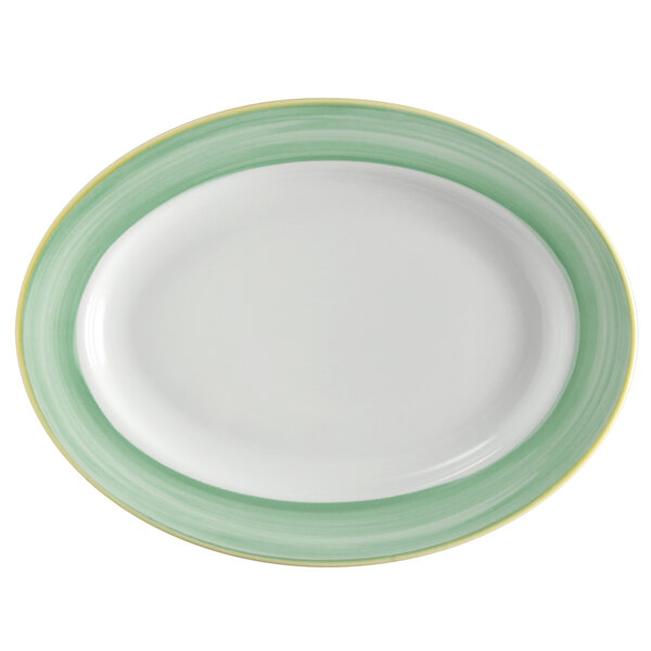 A white porcelain oval platter with a green and yellow rim.