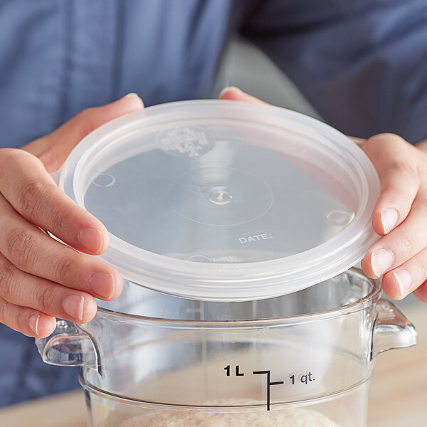A person holding a Vigor translucent plastic lid over a clear container.