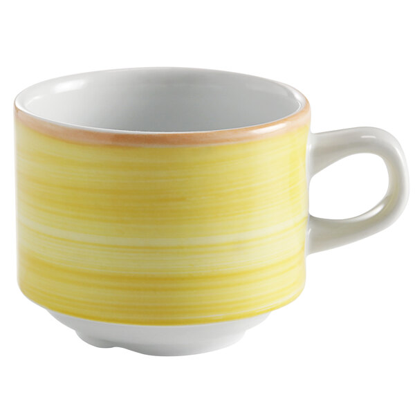 A yellow porcelain tea cup with a white rim and handle.