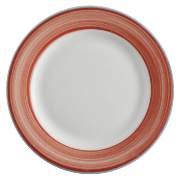 A close-up of a bright white porcelain plate with a coral and blue rim.