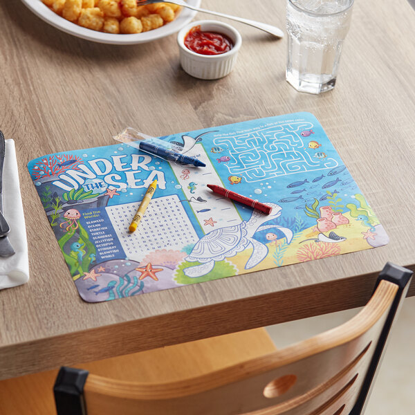 A table with a Choice Kids Under the Sea Themed Interactive Placemat and a bowl of food.