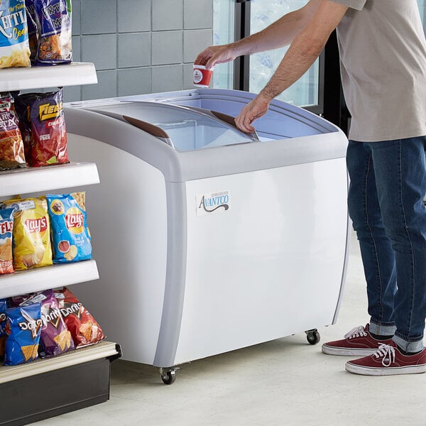 A man opening the Avantco curved top display freezer for ice cream.