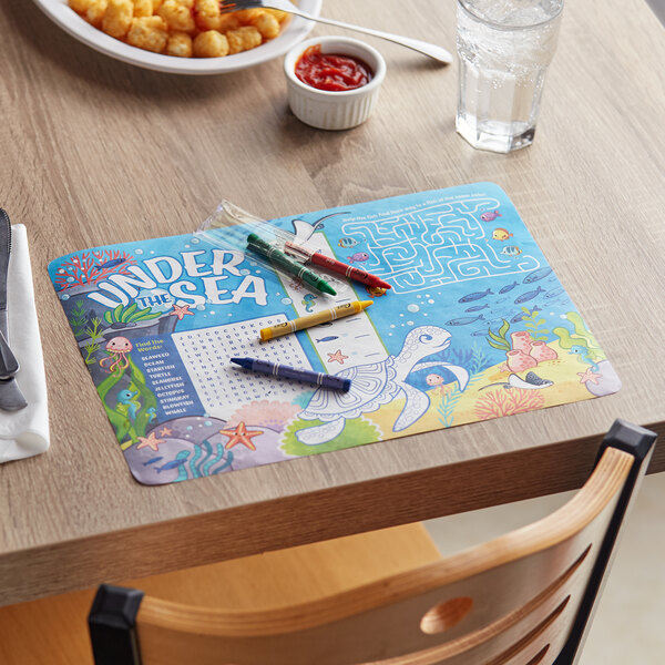 A table with a Choice Kids Under the Sea themed placemat and crayons on it.