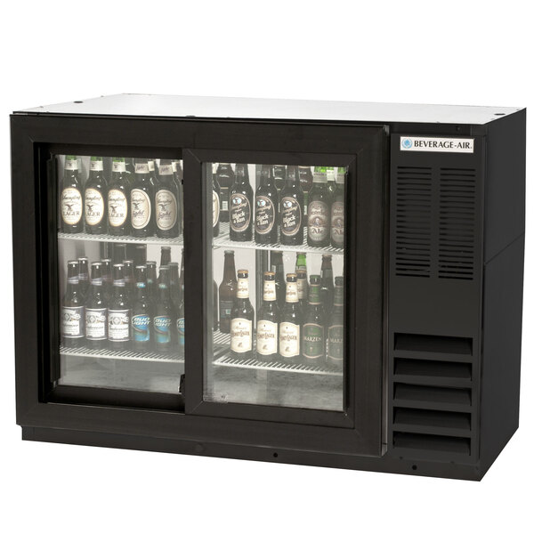 A Beverage-Air black back bar refrigerator with bottles of beer inside.