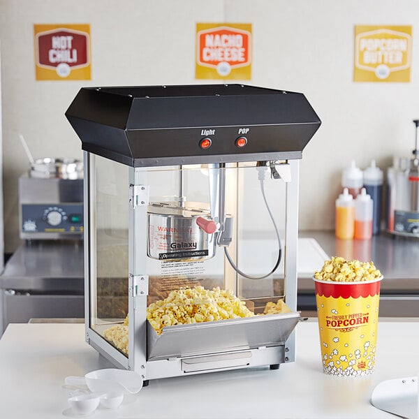 A Galaxy black popcorn machine with popcorn in a container.