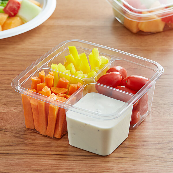 A Fabri-Kal clear plastic container with tomatoes and dip.