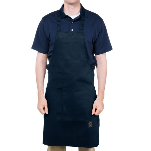 A man wearing a navy blue Chef Revival apron with a black shirt.