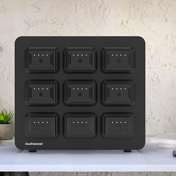 A black Luxor KwikBoost EdgePower 9-bay charging station on a white surface.