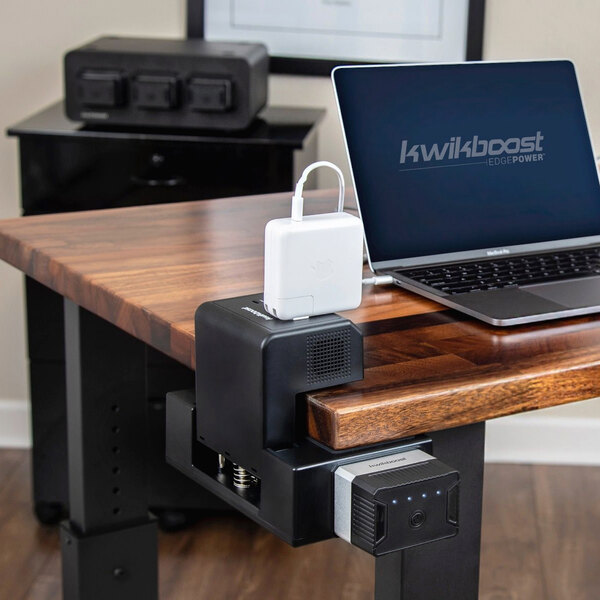A Luxor EdgePower desktop charging station with a laptop and charger on a desk.