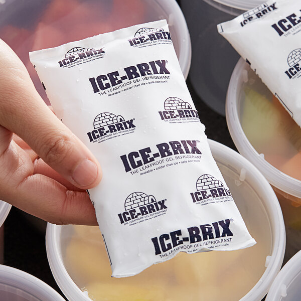 A hand holding a packet of Polar Tech Ice Brix with a white lid.