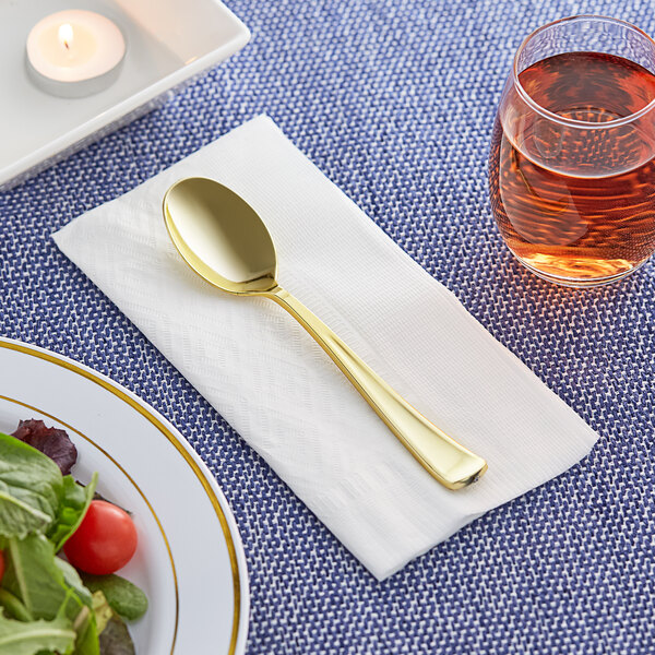 A Visions heavy weight gold plastic spoon on a napkin.