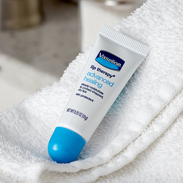 A white and blue Vaseline Advanced Healing Lip Therapy tube on a towel.