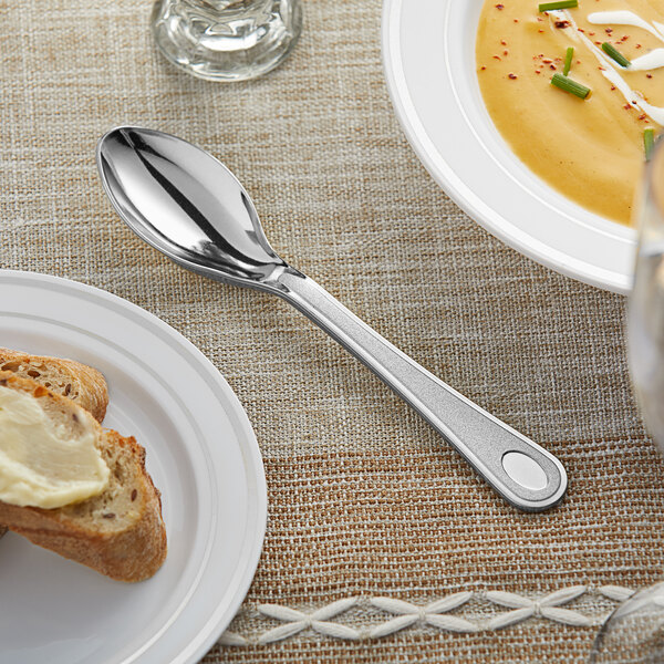 A Visions heavy weight silver plastic spoon on a plate.