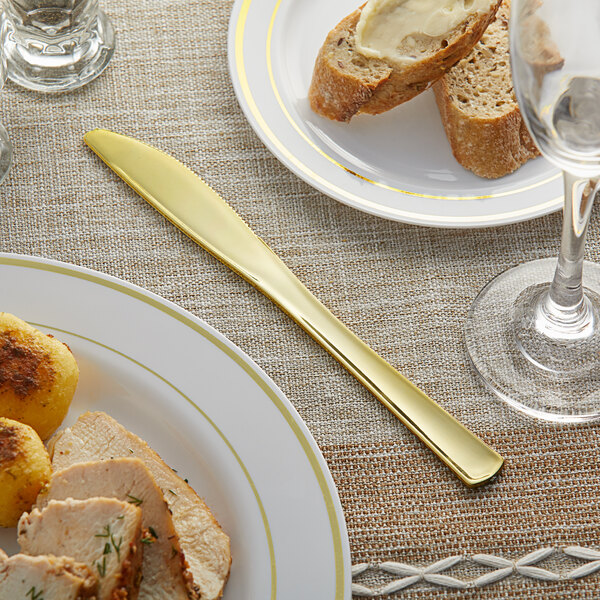A Visions gold plastic knife on a plate of food with a gold border.