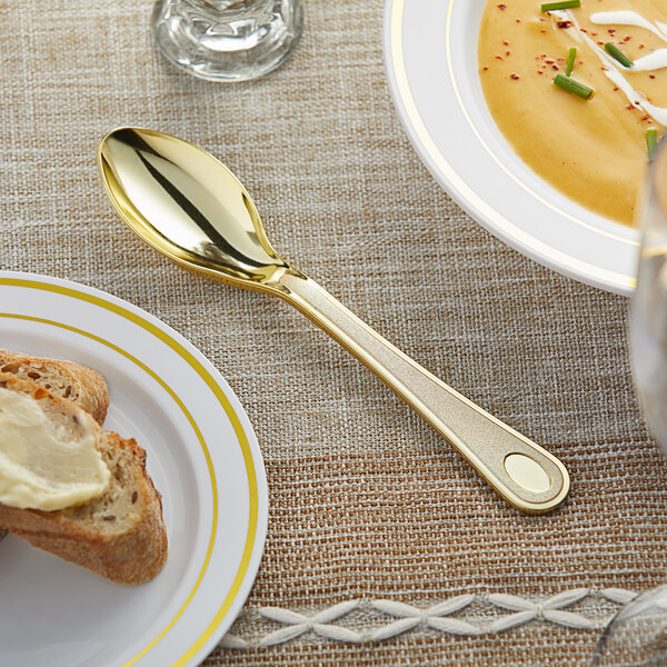 A Visions heavy weight gold plastic spoon on a plate.