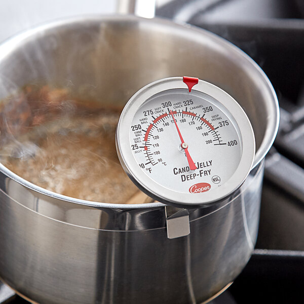 A Cooper-Atkins candy/deep fry probe thermometer in a pot of boiling water.