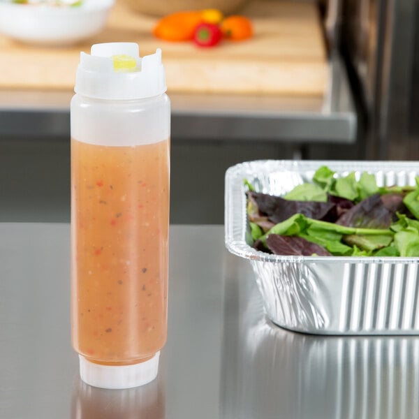 A FIFO Innovations squeeze bottle with salad next to it.