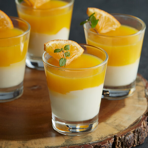 Glasses of Les Vergers Boiron Mandarin Orange 100% Fruit Puree desserts with oranges on top.