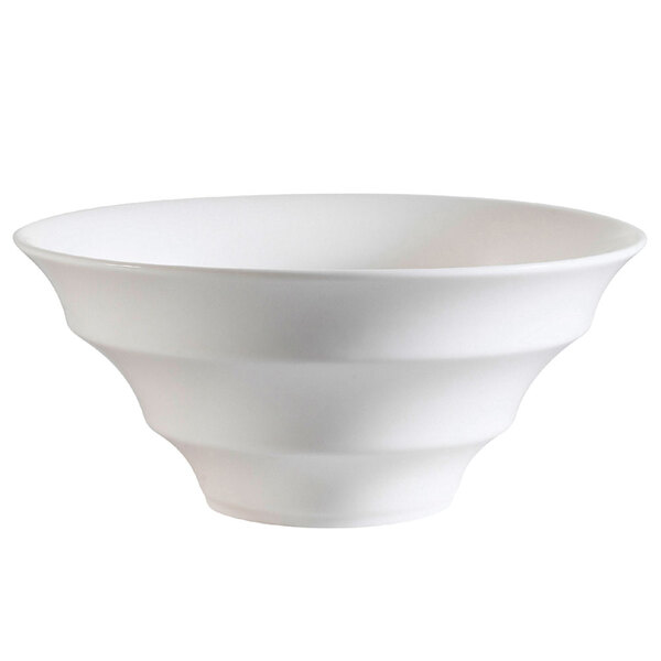 A close-up of a CAC Bone White porcelain bowl with a curved design.