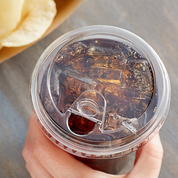 A hand holding a Choice clear plastic cup with a clear drink in it and a clear strawless/sip lid.