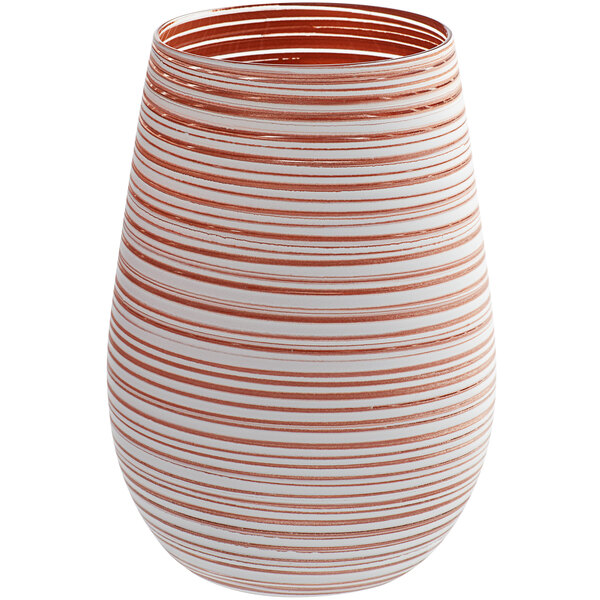 A close up of a white and orange striped Stolzle Twister wine glass.