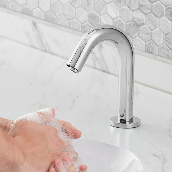 A person washing their hands under a Waterloo Deck Mount electronic faucet.