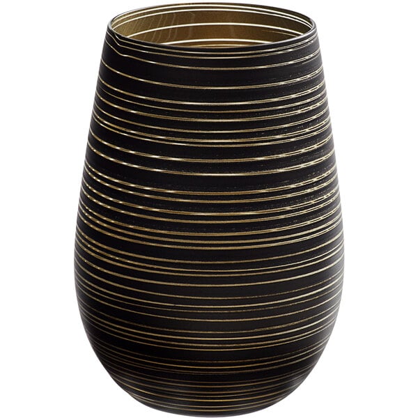 A close up of a black and gold striped Stolzle Twister stemless wine glass.