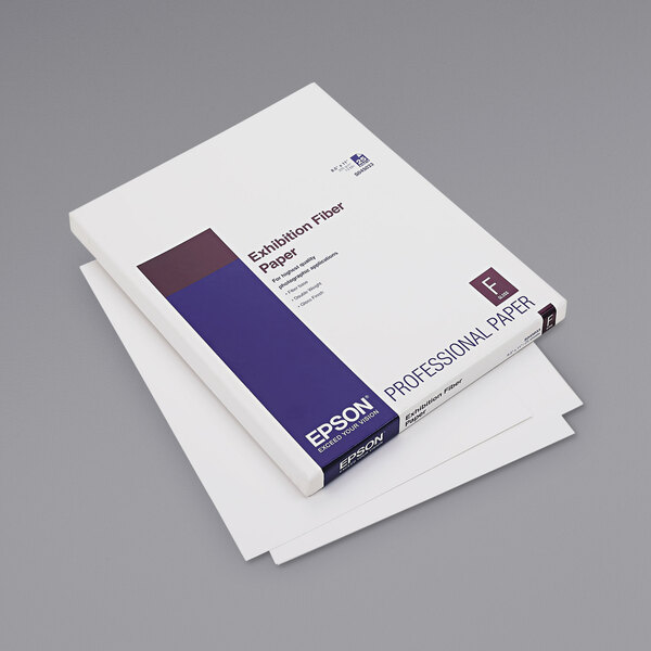 A close-up of a white box of Epson Exhibition Fiber paper with a white and purple cover.