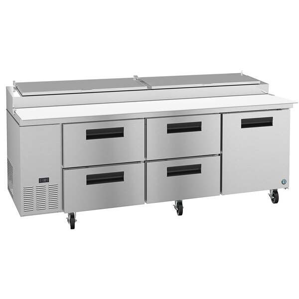 A stainless steel Hoshizaki pizza prep table with four drawers on a counter.
