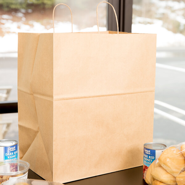 A brown Duro paper bag with handles holding a loaf of bread and cans.