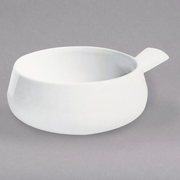 A white Hall China side handle soup bowl.
