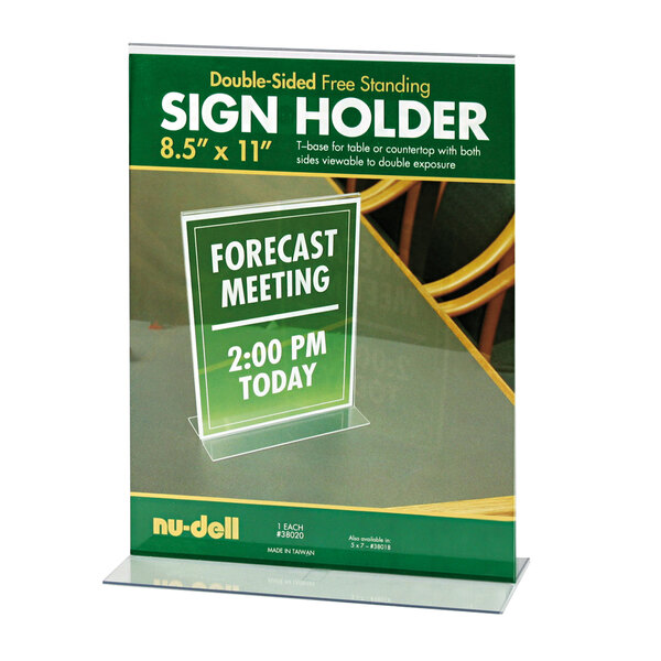 A NuDell clear acrylic double-sided sign holder on a table with a green and white sign inside.