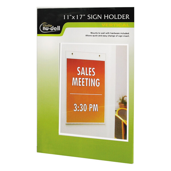 A NuDell clear plastic wall mount sign holder displaying a white sign with the words "sales meeting"