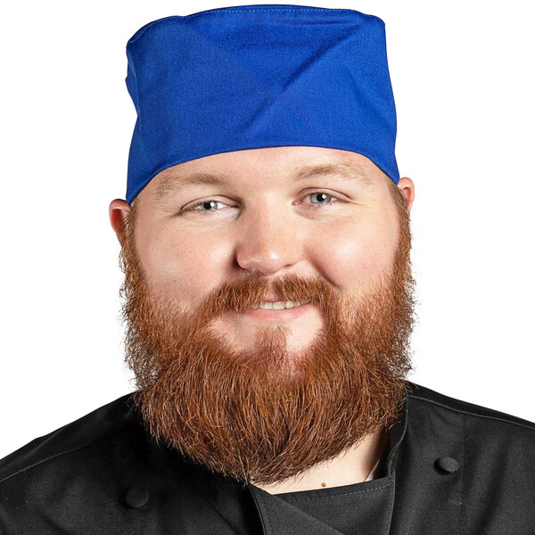 A bearded man wearing a royal blue Uncommon Chef skull cap.
