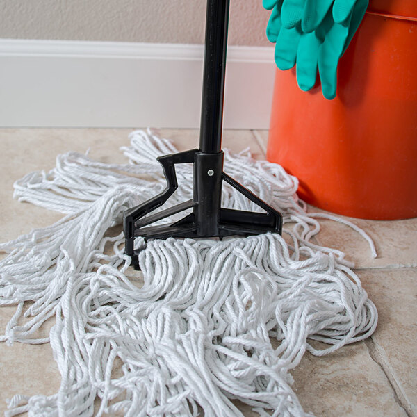 A Carlisle Sparta mop with a Carlisle mop handle and plastic head sitting on a mop bucket.