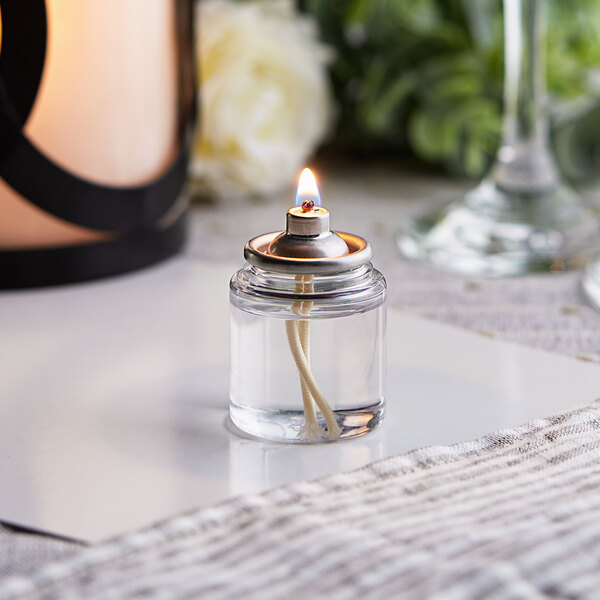 A glass container with a Leola Candle fuel cartridge inside and a flame.