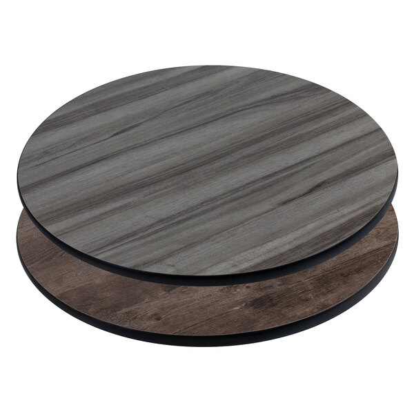An American Tables & Seating round wood table with a gray and brown reversible laminate top.