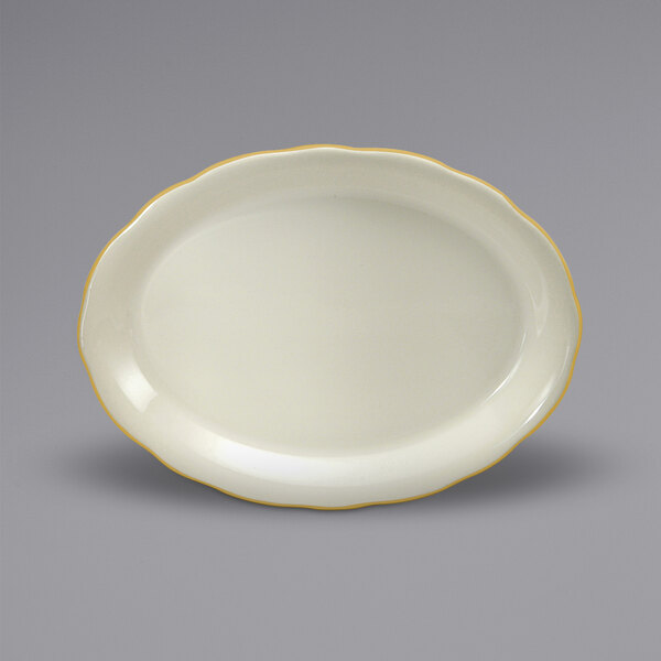 A white oval platter with scalloped edges and gold trim.
