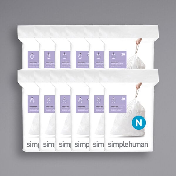A group of simplehuman white custom fit trash can liner packages.