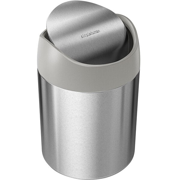 A simplehuman brushed stainless steel countertop trash can with a swing top lid.