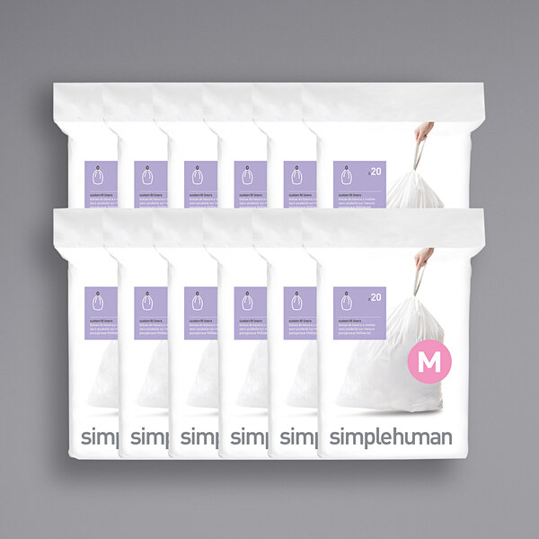 A group of simplehuman white Code M trash can liner packages.