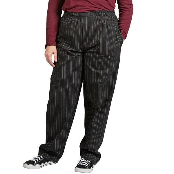 A person wearing Uncommon Chef pinstripe chef pants with white pinstripes.