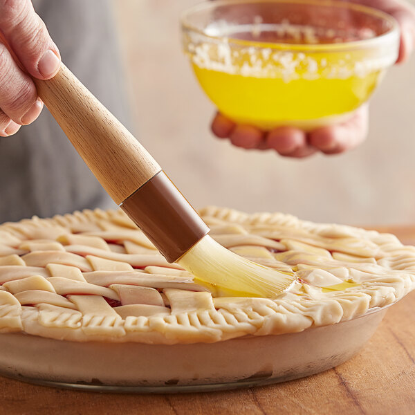 A person using a Thunder Group round pastry brush to paint a pie.