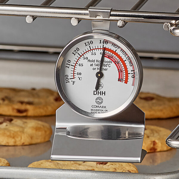 A Comark hot holding thermometer on a rack of cookies.