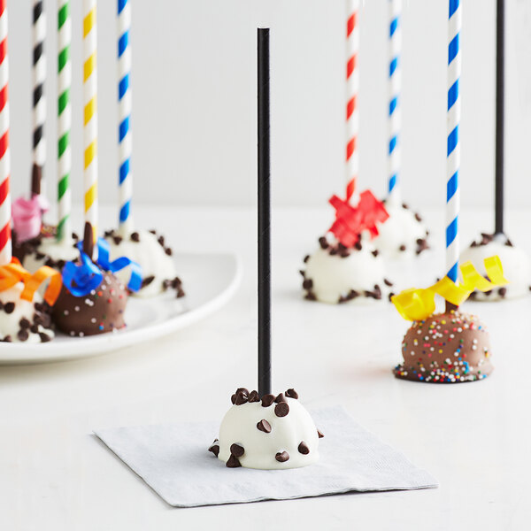 A group of chocolate covered cake pops on EcoChoice black paper cake pop sticks.