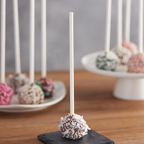 EcoChoice white paper cake pops on a black plate with white sticks.