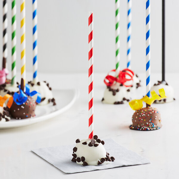 EcoChoice red stripe paper cake pop sticks in a group of chocolate covered cake pops.