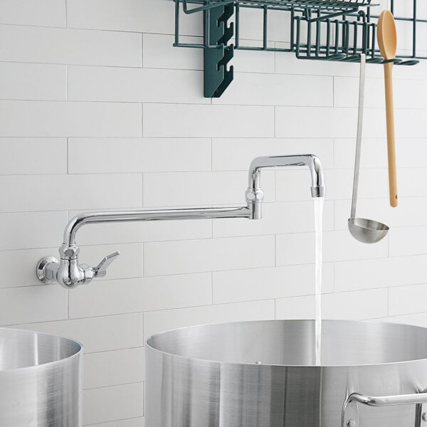 A Waterloo silver pot and kettle filler faucet with a double-jointed swing spout over a metal pot on a rack.