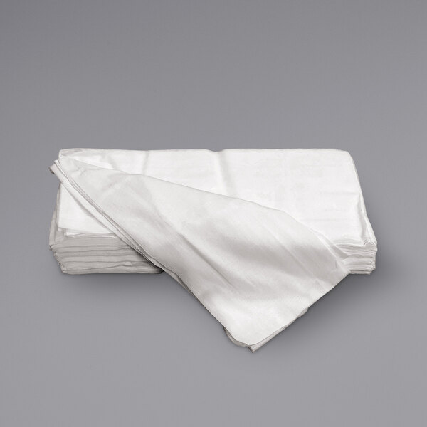 A stack of Monarch Brands Grade 60 bleached cheesecloth on a grey surface.