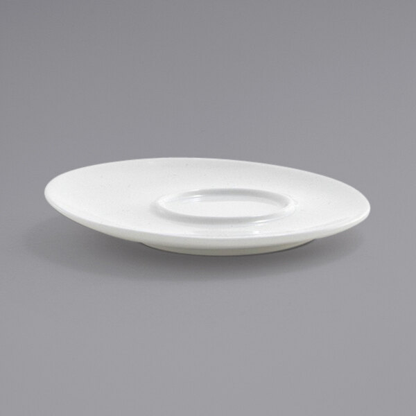 A white plate with a circular edge and a small dish on top.